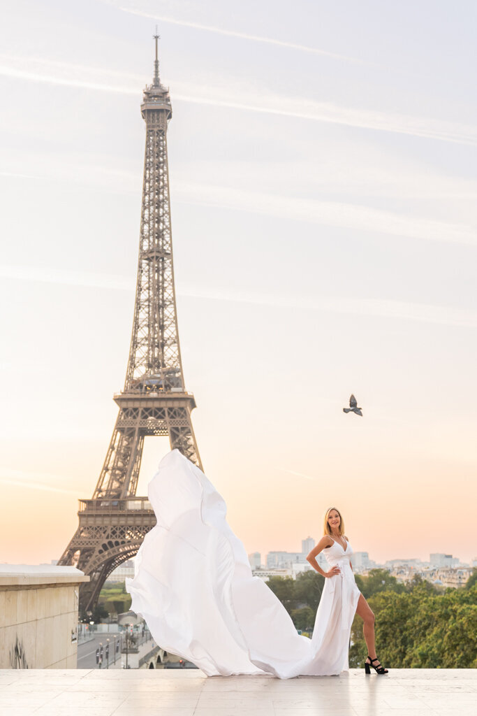 Flying dress photoshoot at Trocadero - woman in flowing white dress during sunrise Paris portrait session with Eiffel Tower view