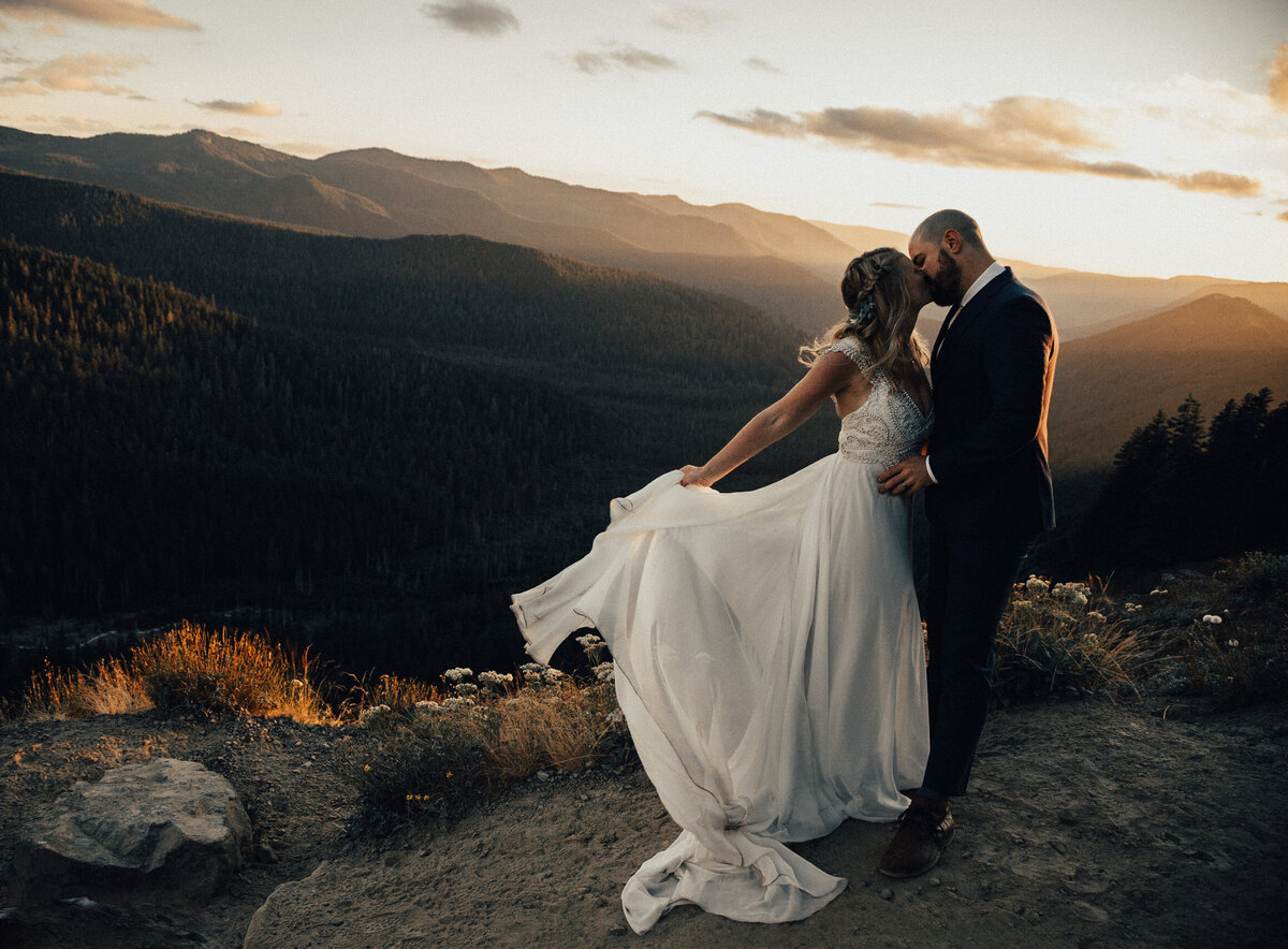 Bride and groom elope and share a kiss on Mailbox peak with views of Mount Hood