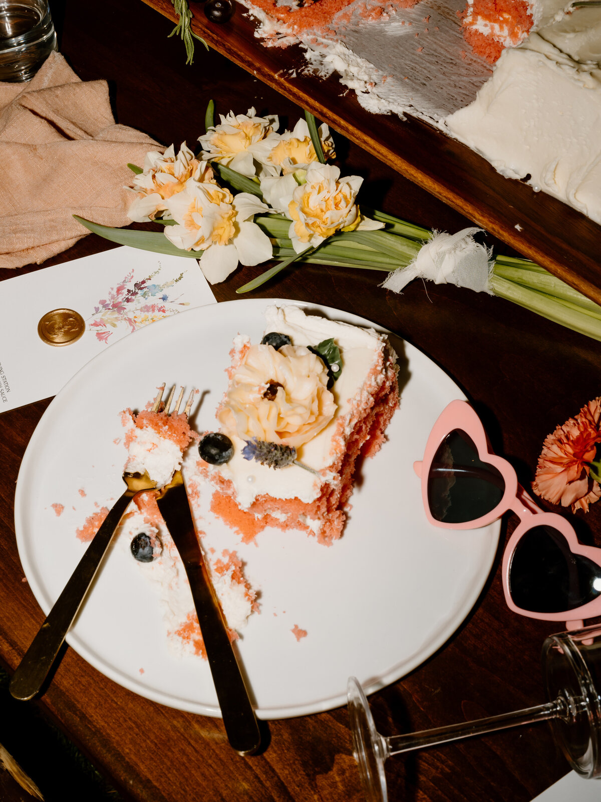 Cake, sunglasses and flowers on a table