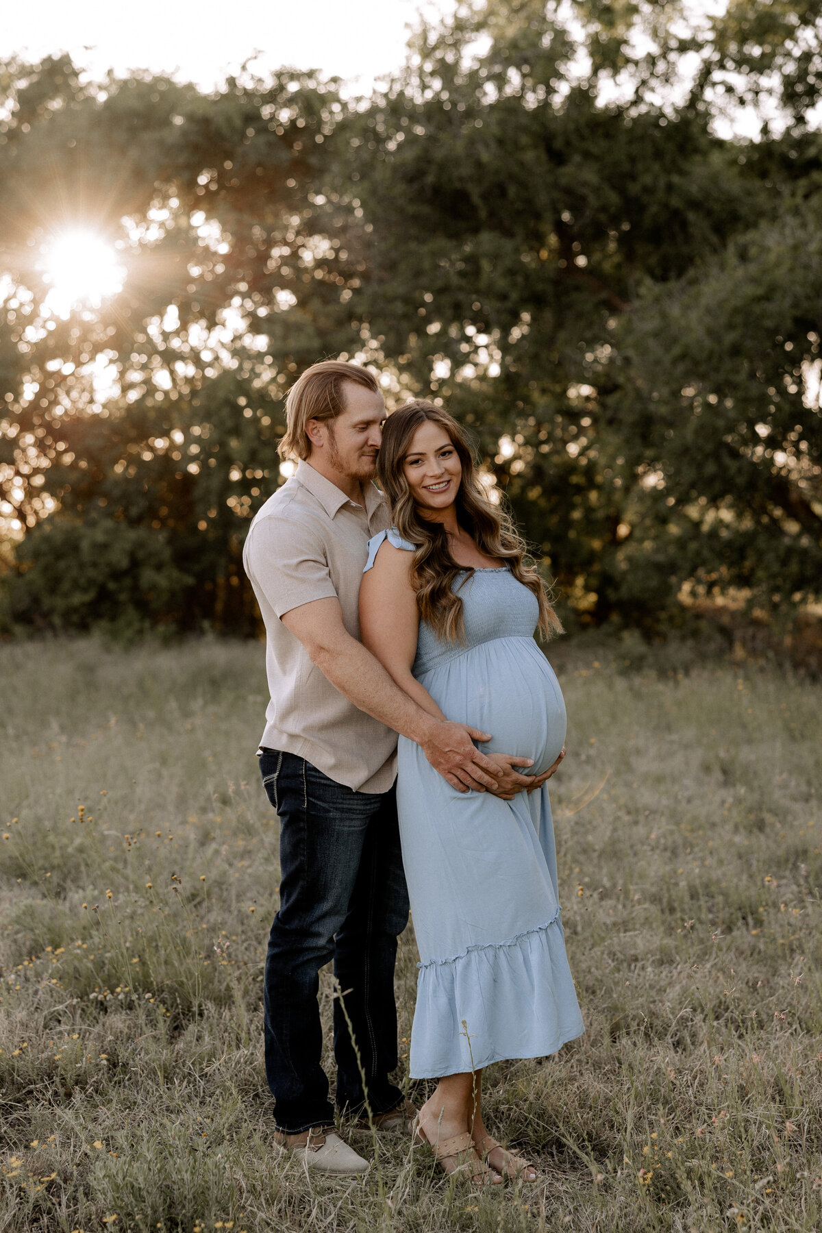 maternity couple in a field with trees