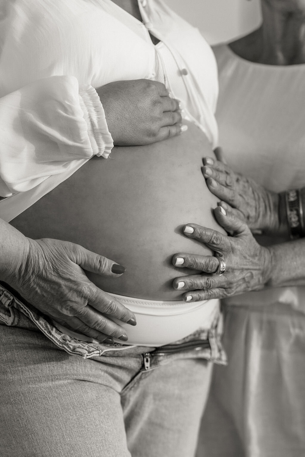 Three generations sharing a quiet moment around a baby bump during a Miami maternity session.