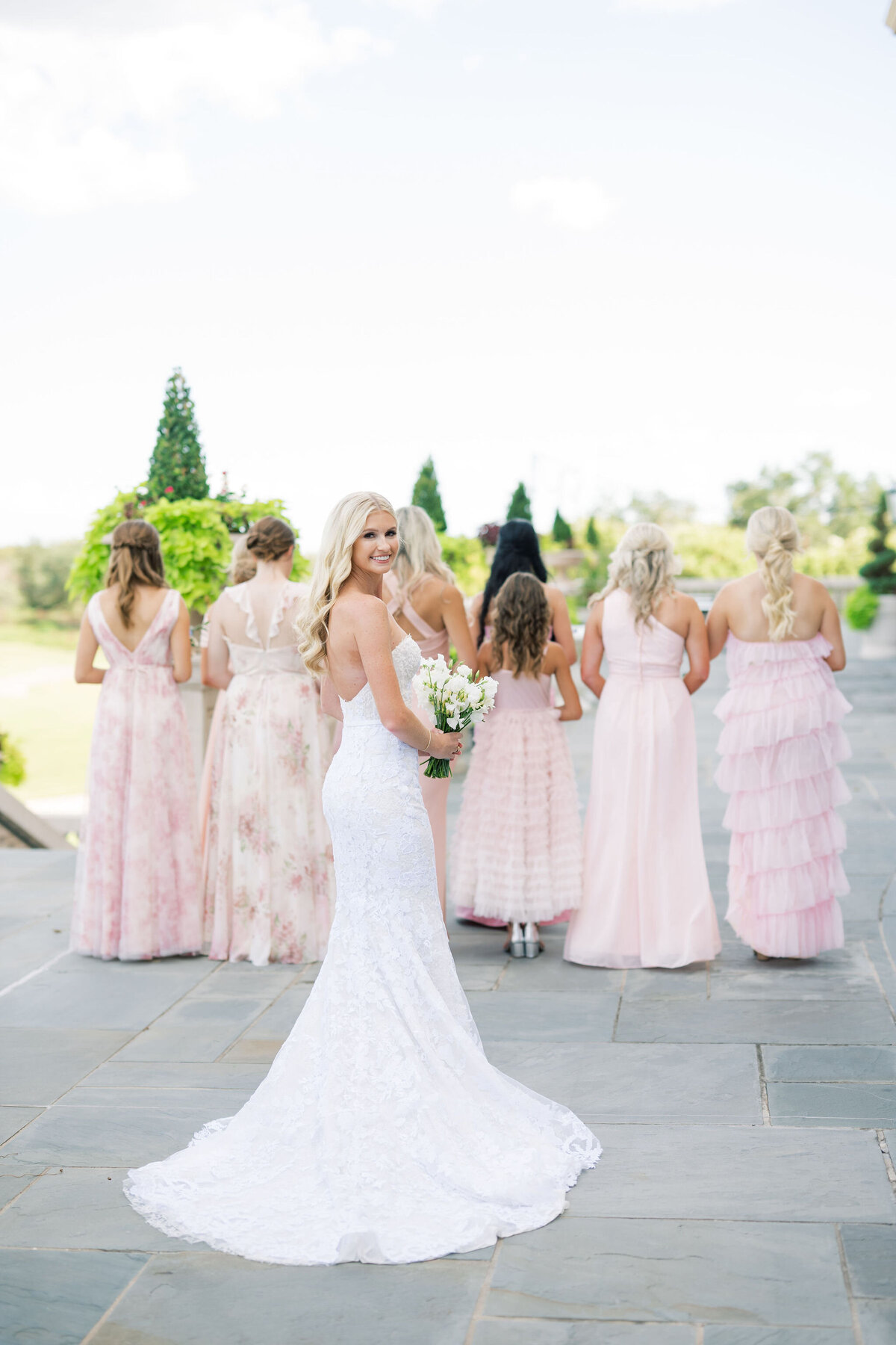 Bride standing in front of her bridesmaids while they face away from her