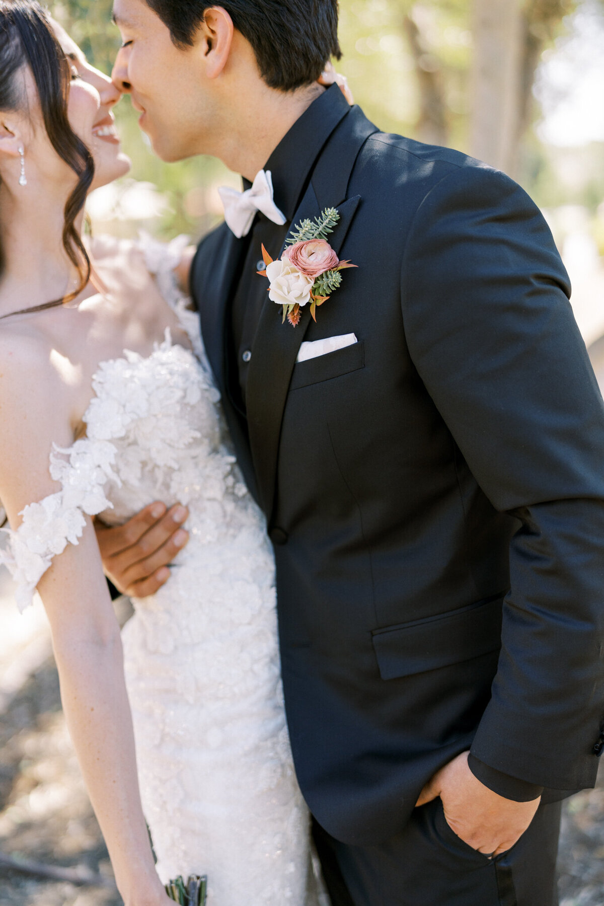 Romantic close-up of bride and groom—elegant florals, soft lace, and a tender moment captured in golden vineyard light.