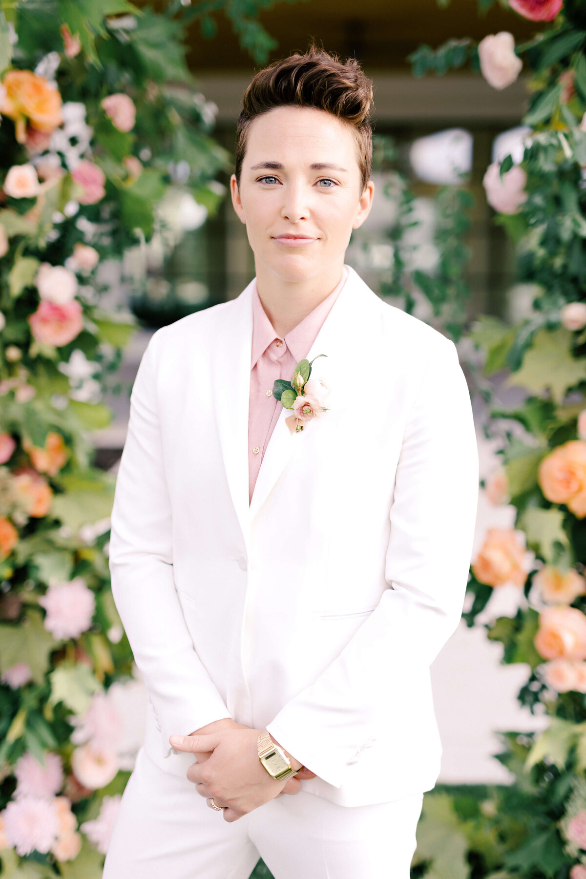 Wedding day attire with a beautifully tailored white tuxedo by The Suit Shop with a blush button-down
