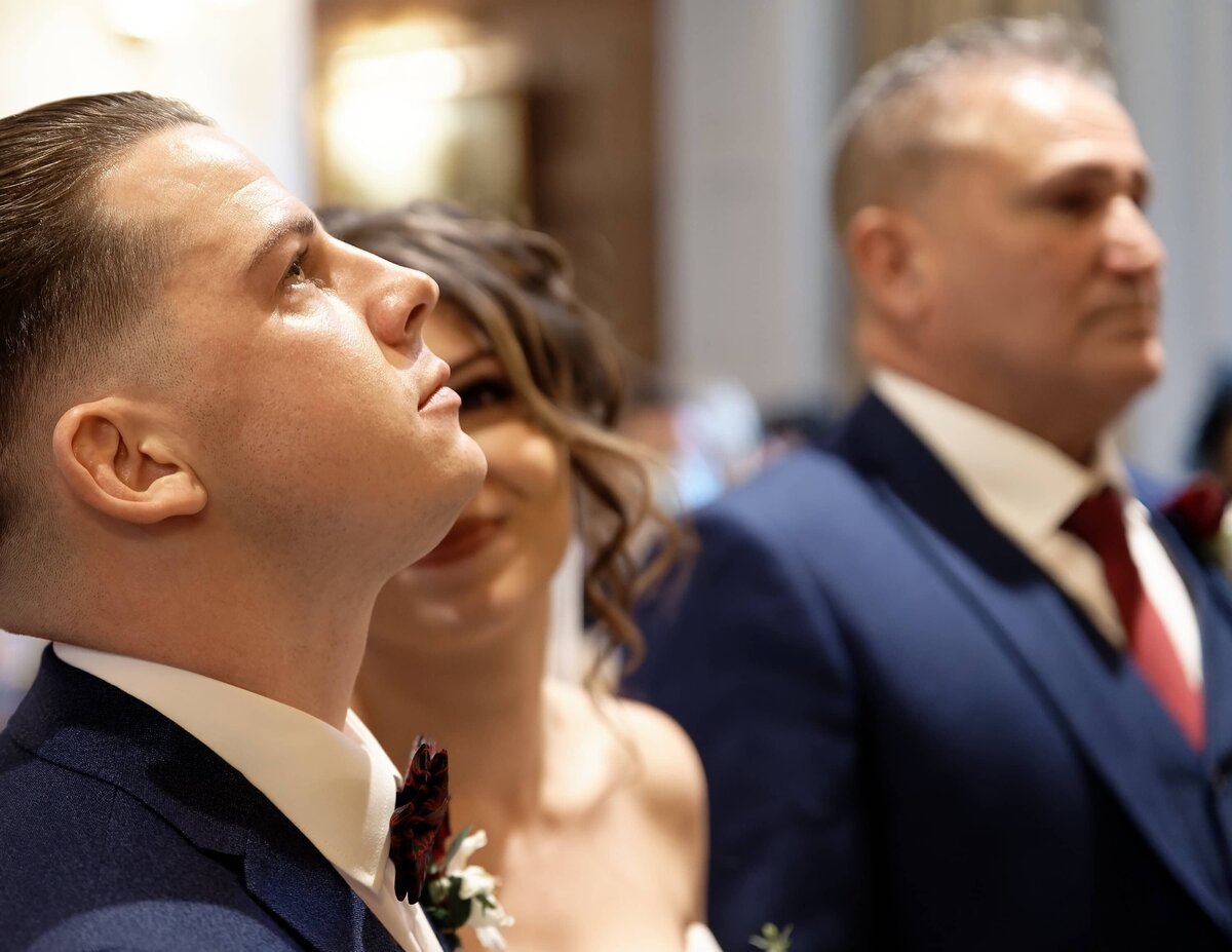 Bride smiling at her emotional groom during their wedding ceremony