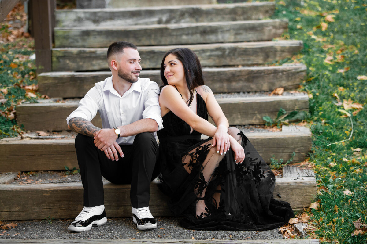 engaged_couple_stare_at_each_other_on_stairs