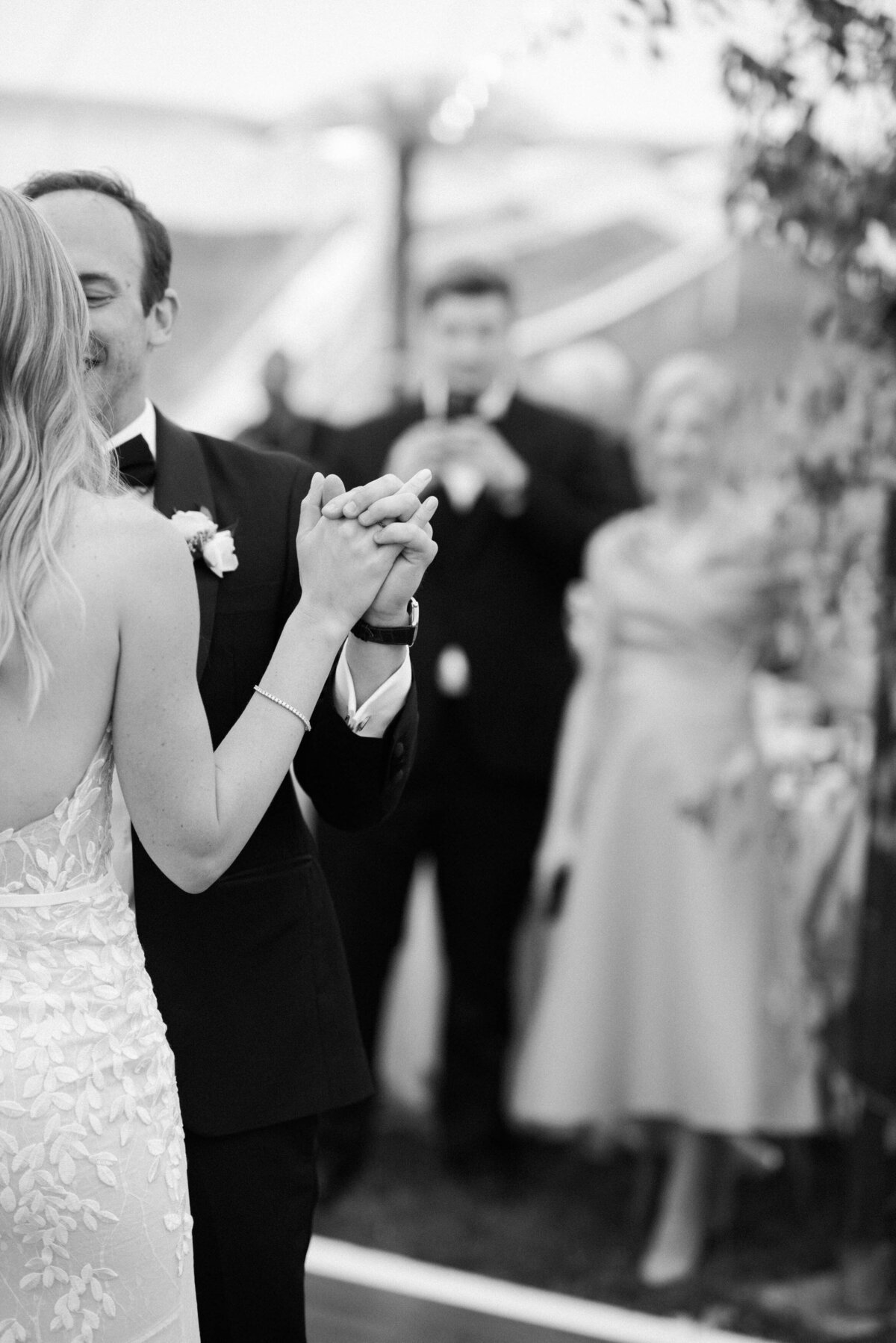 Bride and groom hold hands on the dance floor