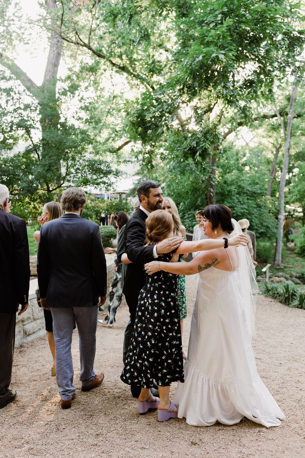 Bride hugging wedding guests at Umlauf Sculpture Garden, Austin