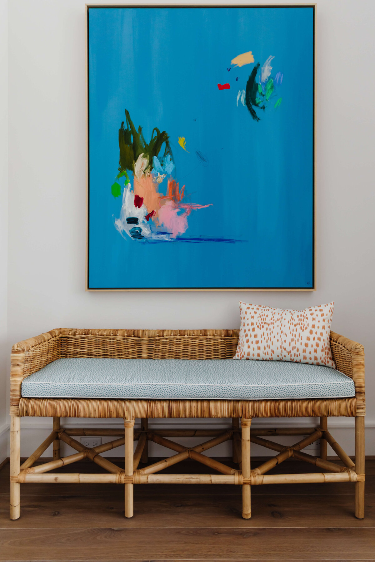 oyster creek studios memorial new build blue abstract painting over wooden wicker bench with light blue cushion