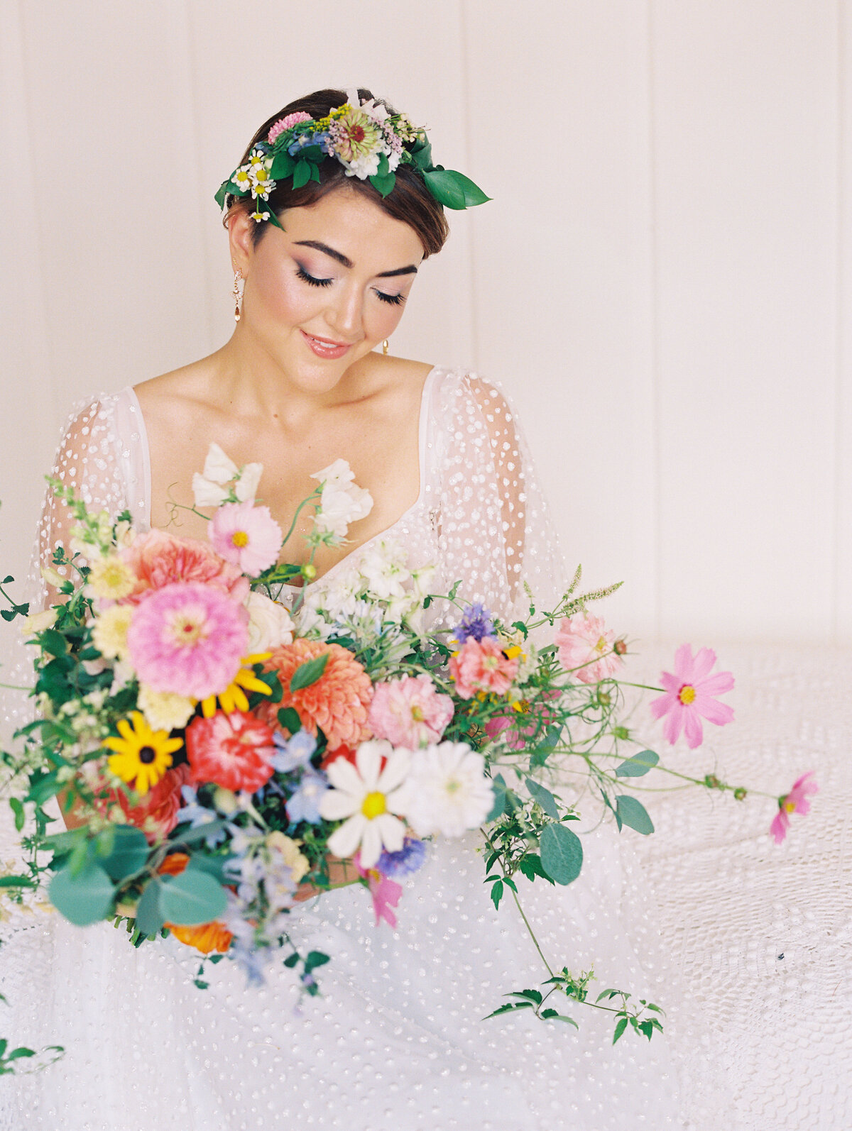 Bride holding a colorful bridal bouquet with flower crown