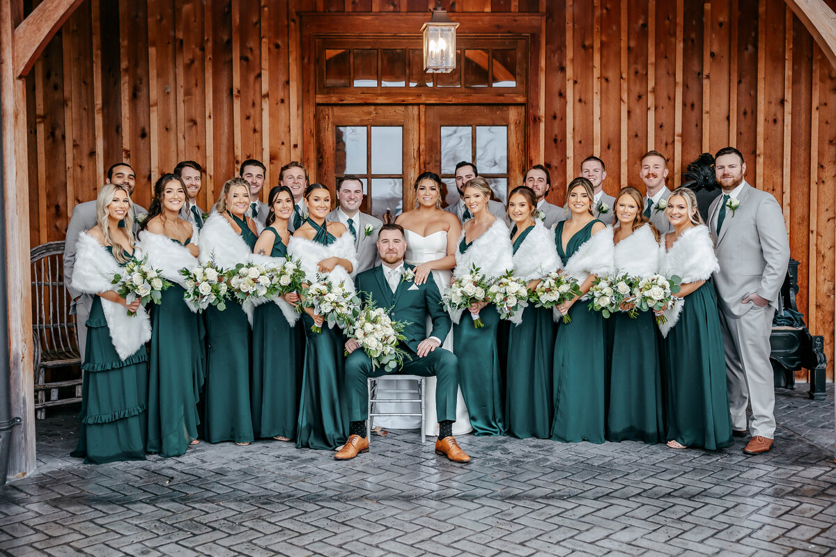 Beautiful bridal party photo captured by Style & Grace Photography at The Stone House in St. Charles, MO, set in a stunning winter wonderland, showcasing the bridal party in the season’s magical setting.