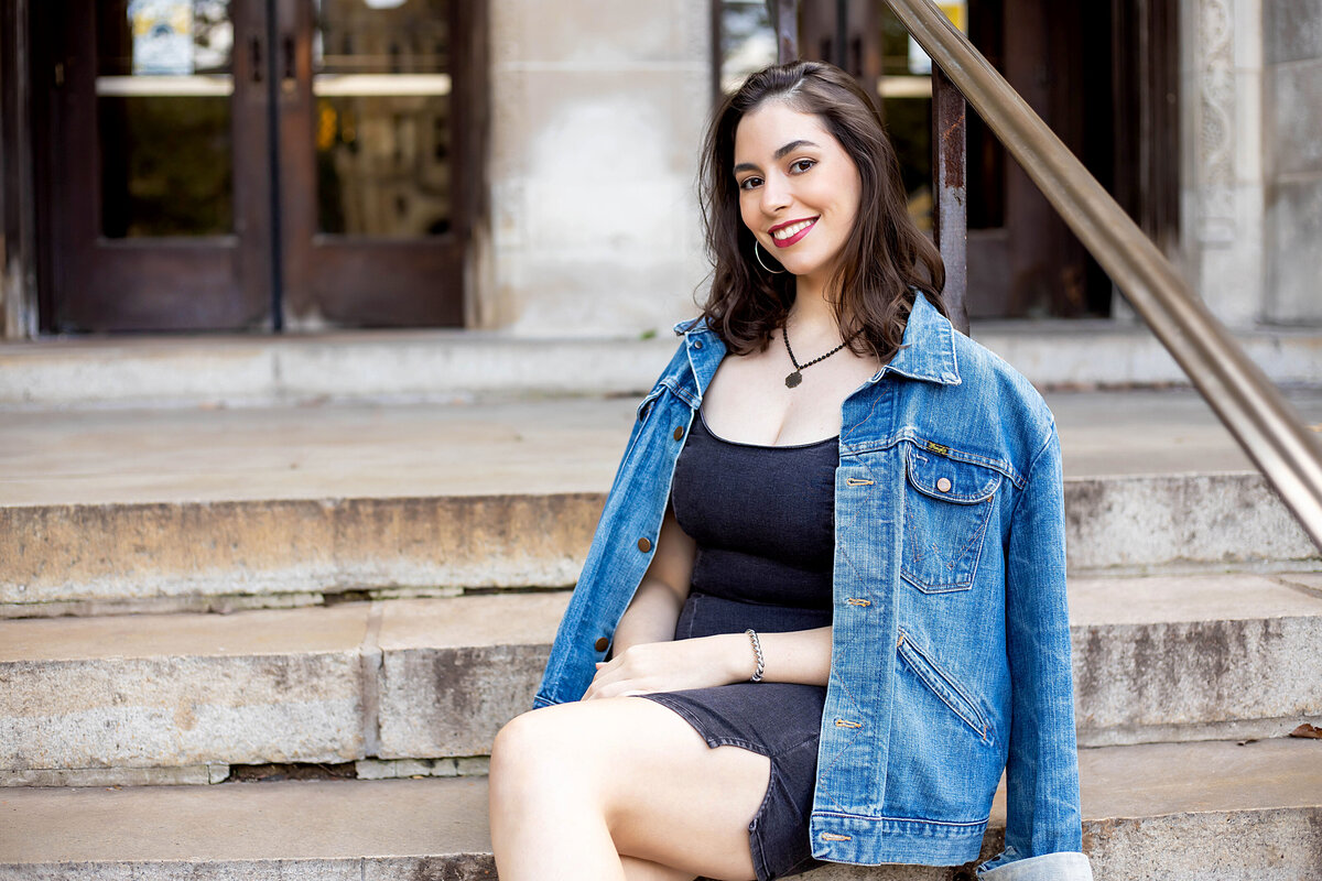 Ann Arbor U of M Law Quad Senior Photoshoot | Ann Arbor Michigan Senior Photographer, Senior girl with black hair in blue jean jacket and black jean dress on steps