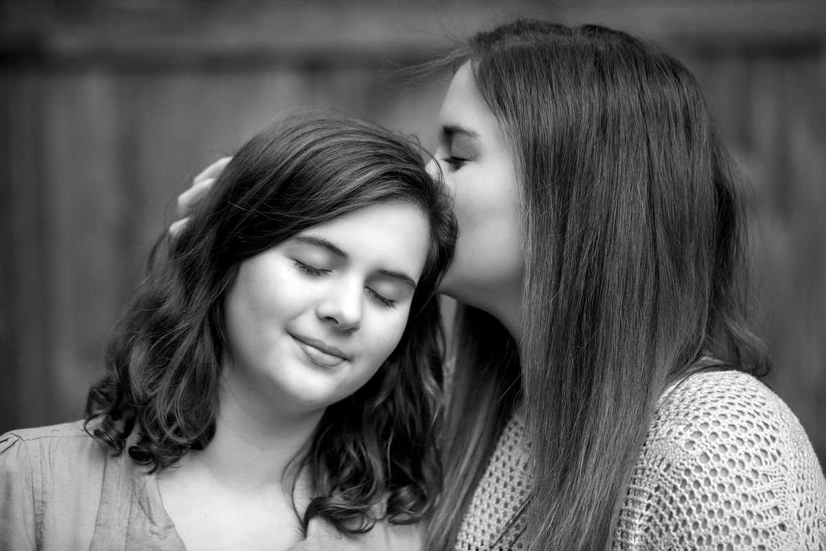 Sisters and best friends having a tender moment during outdoor photo session