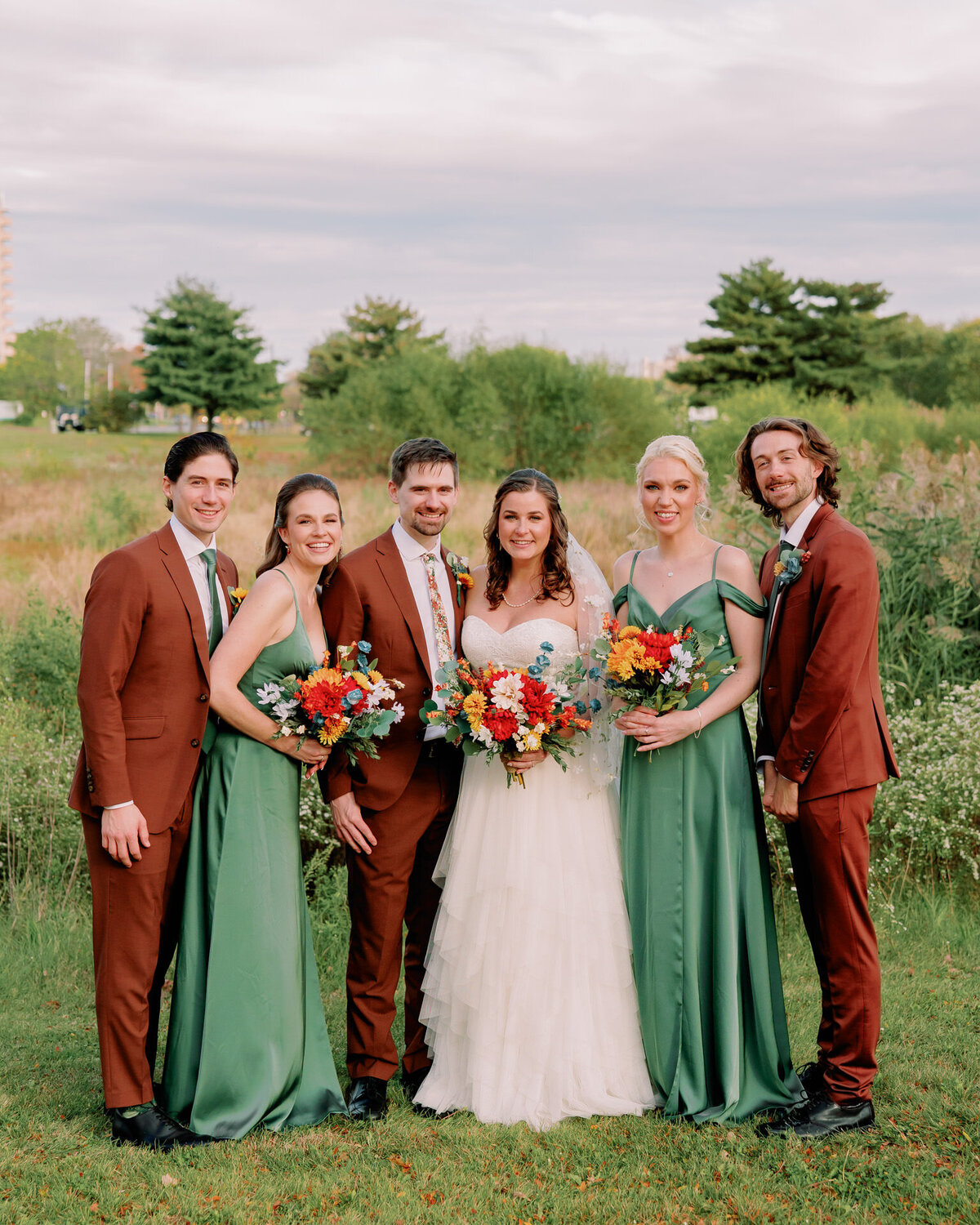 Newlyweds smiling with their wedding parties 