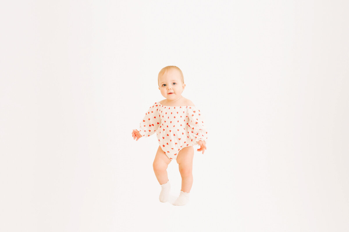 baby girl walking in photography studio in Springfield MO kids photography studio