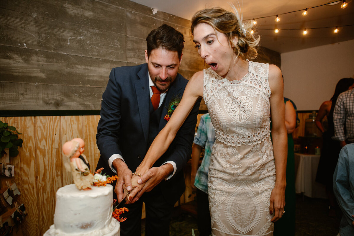 Ali and Brian cut their cake, making funny faces.