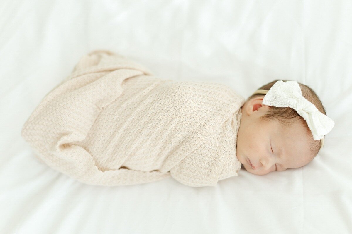 newborn baby girl swaddled in pink blanket for houston newborn session
