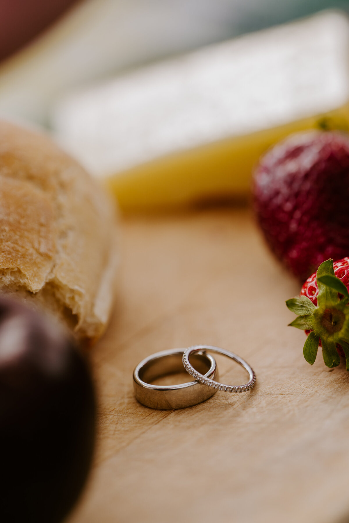 Close-up of wedding rings on picnic board.