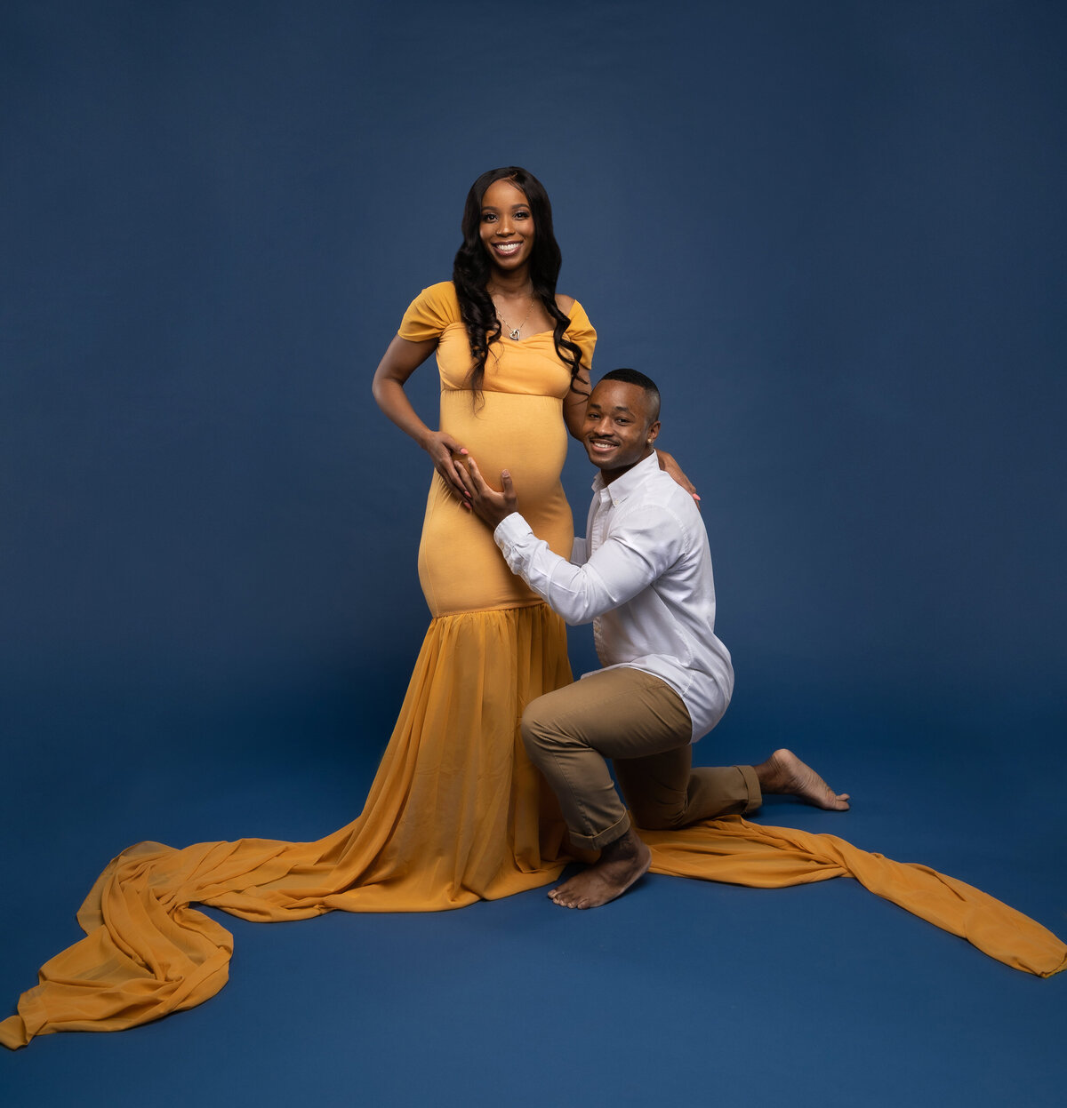 Black couple posing for maternity