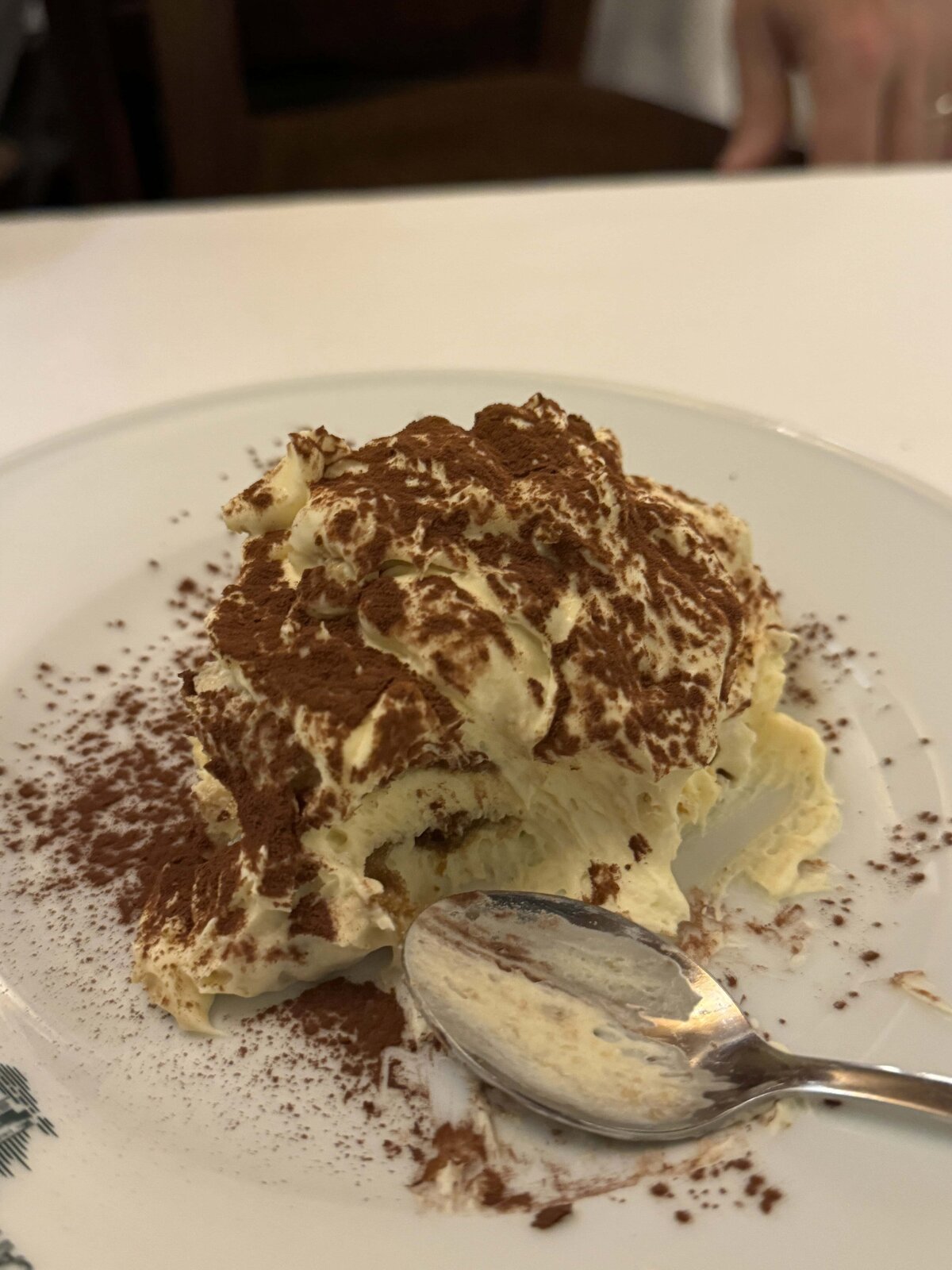 Tiramisu with a bite taken out of it next to a spoon