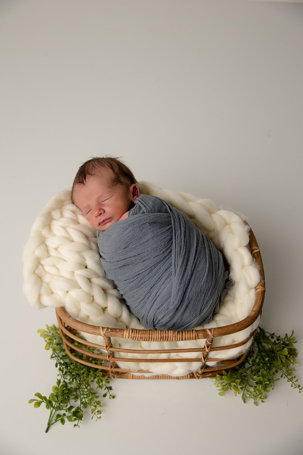 baby boy swaddled in light blue