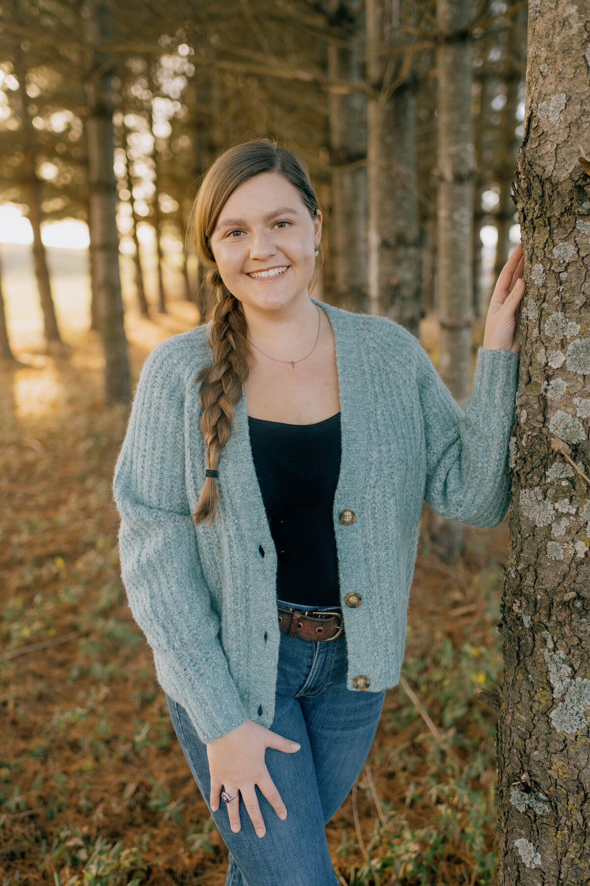 Sydney sits on the hood of an old car in Timberville.