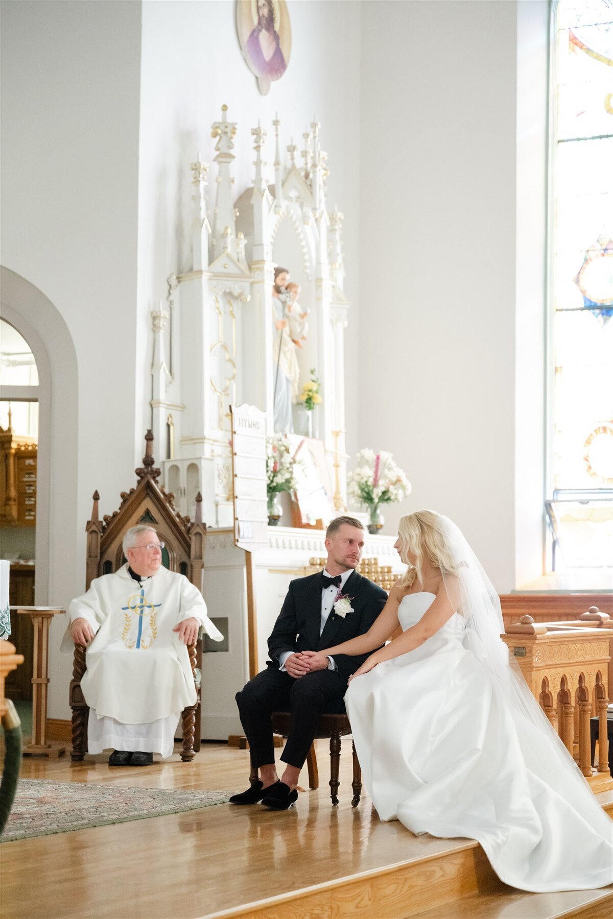 Beautiful photo of bride and groom sharing a glance during their St.Anne's cathedral wedding ceremony on Mackinac Island