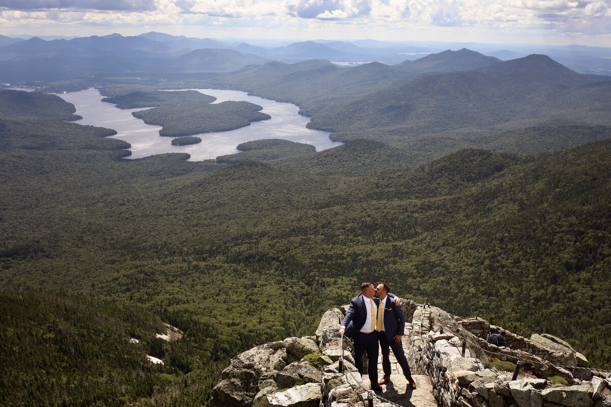 Grooms kissing on mountaintop