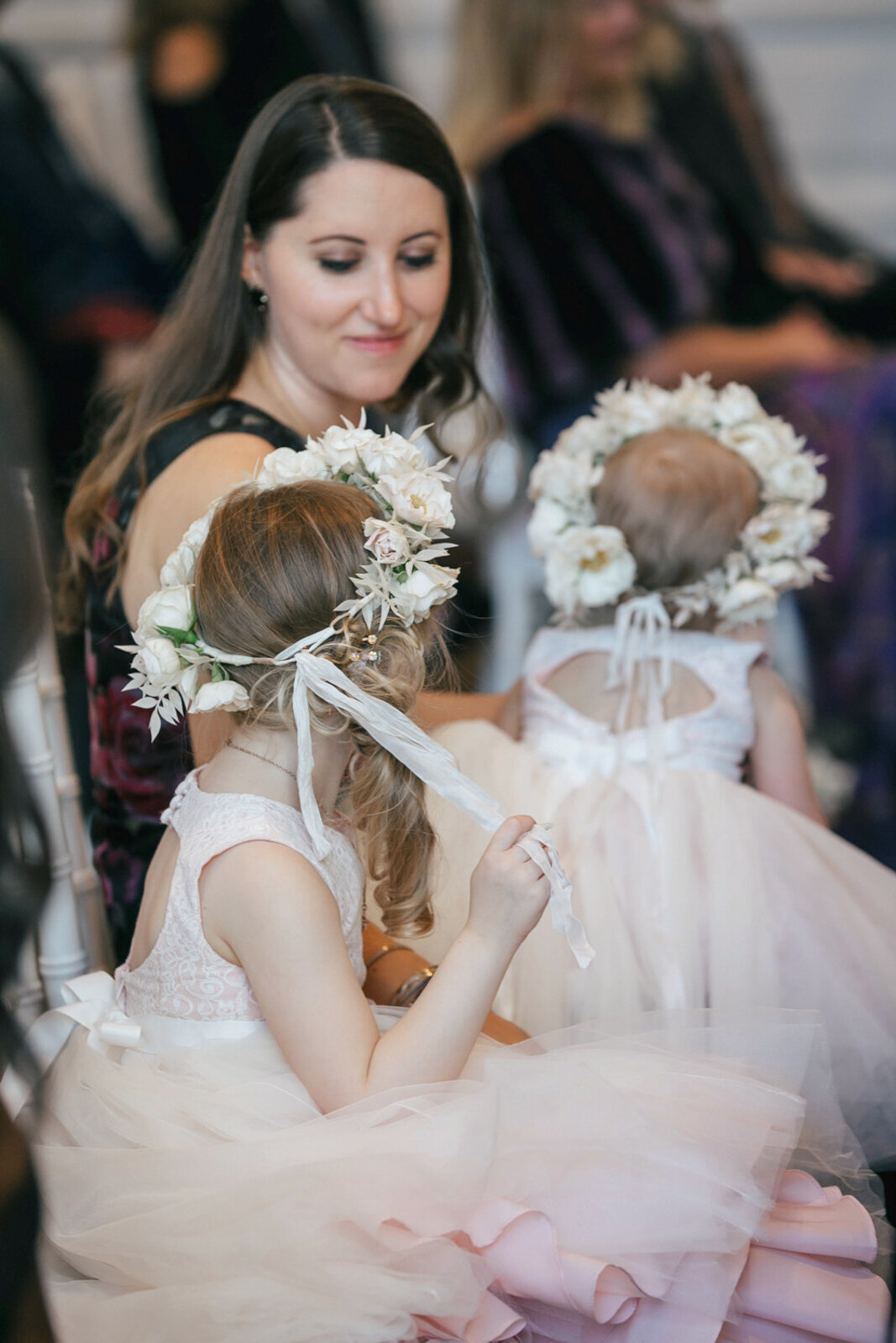 Flower girls wearing floral wreaths during a wedding ceremony at The Adolphus hotel.

