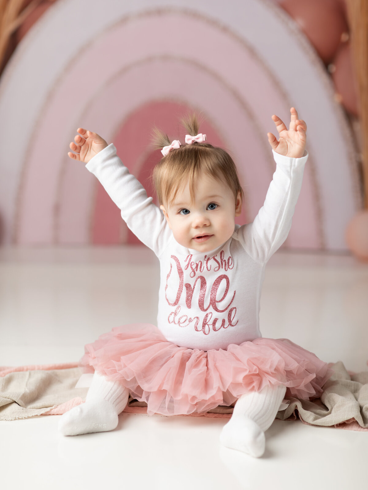 one year old girl in pink and white tutu for first birthday photoshoot