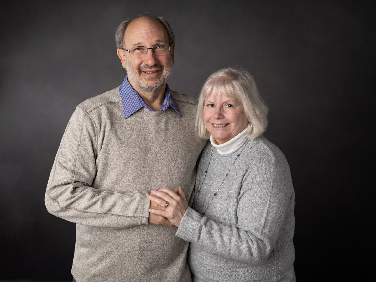 husband and wife holding each other for studio portraits