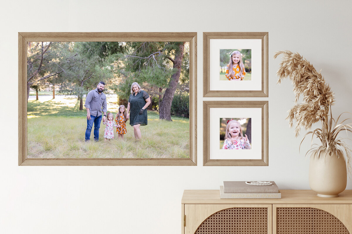 Three family portraits of different sizes hanging in an entryway on a white wall.