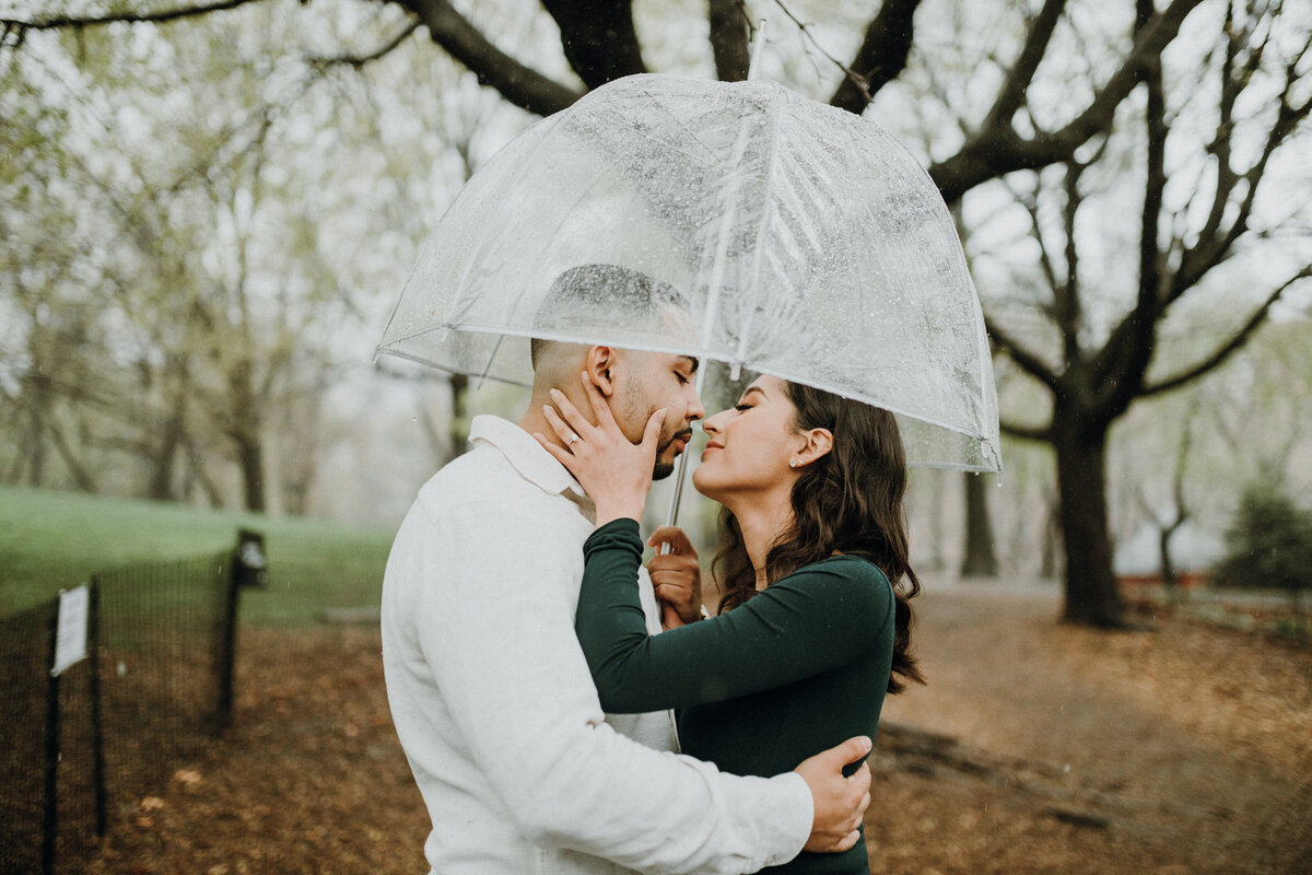 Couple standing under an umbrella kissing