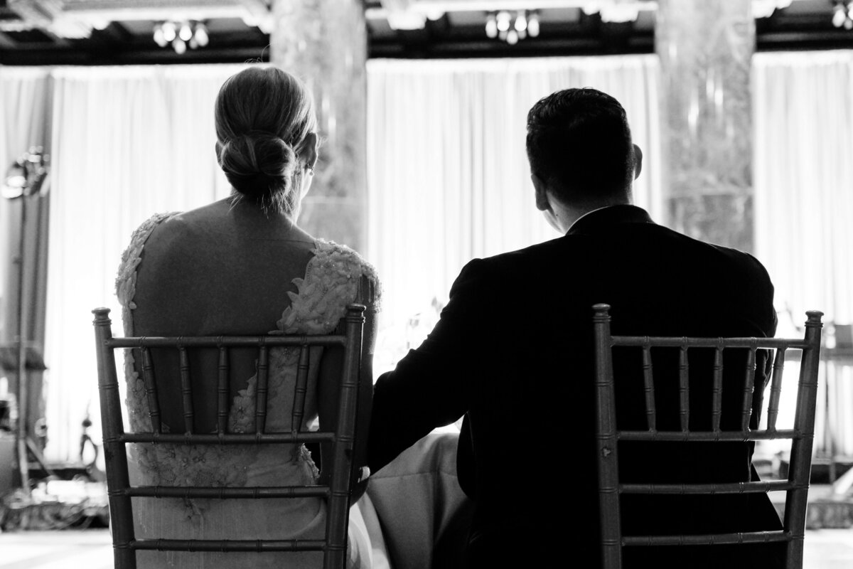 candid moment of bride and groom listening to toasts