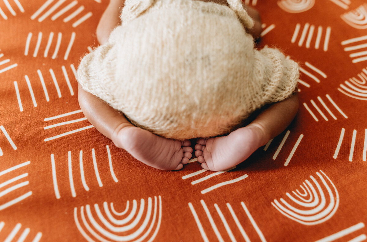 Infant photography session with newborn sleeping in a crib.