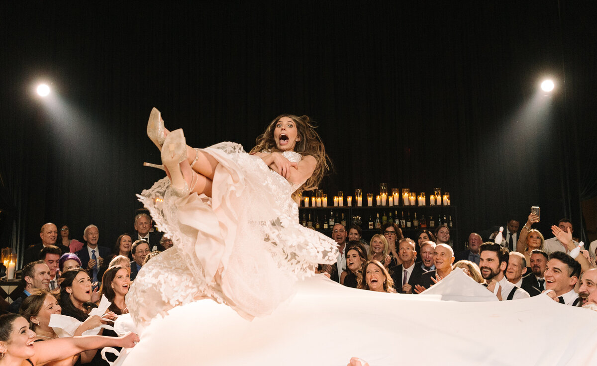 Bride being thrown in the air during a hora