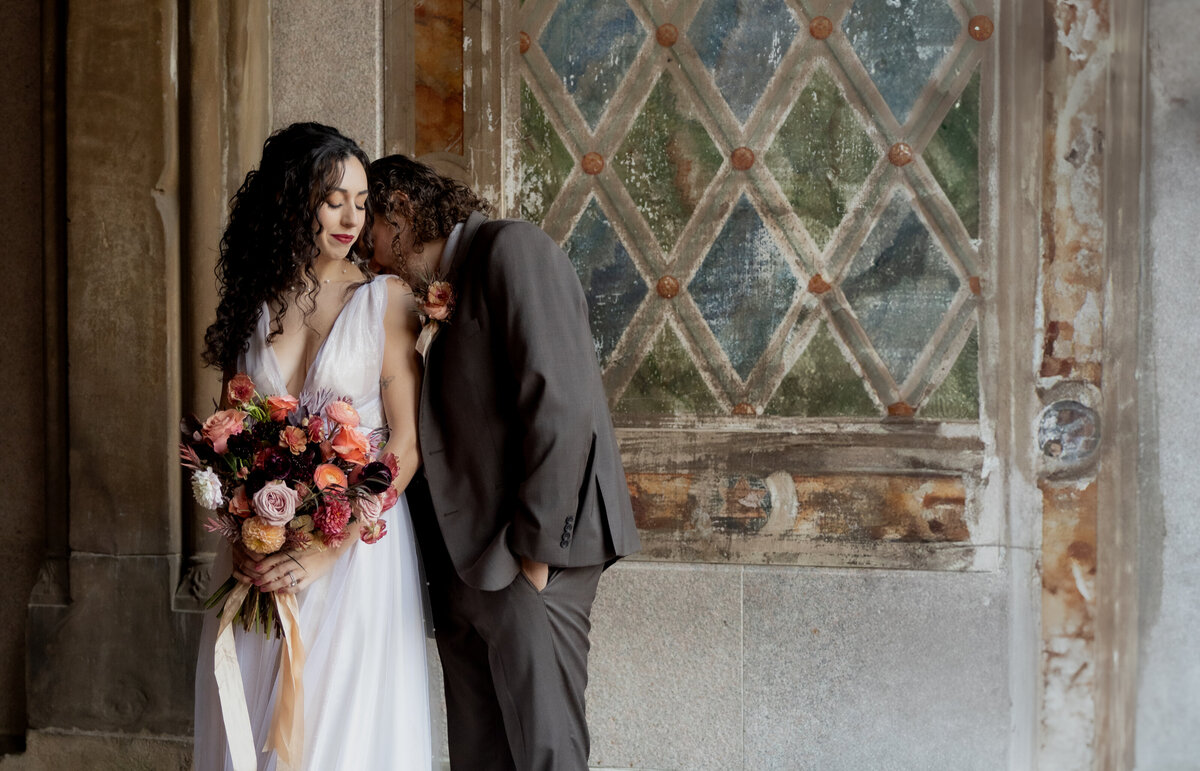 The couple sharing a tender moment beneath Central Park’s beautiful stone arches.