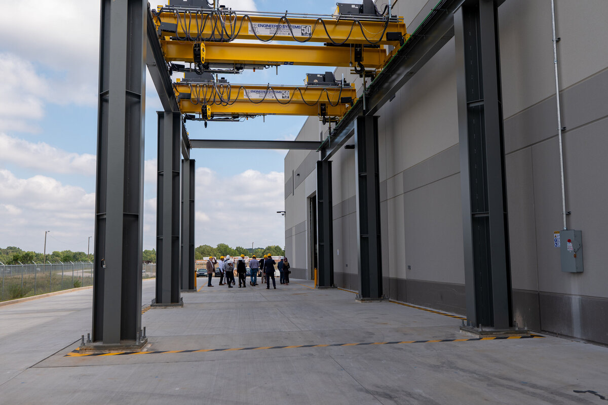 A group of people standing at the opposite side of a warehouse building 
