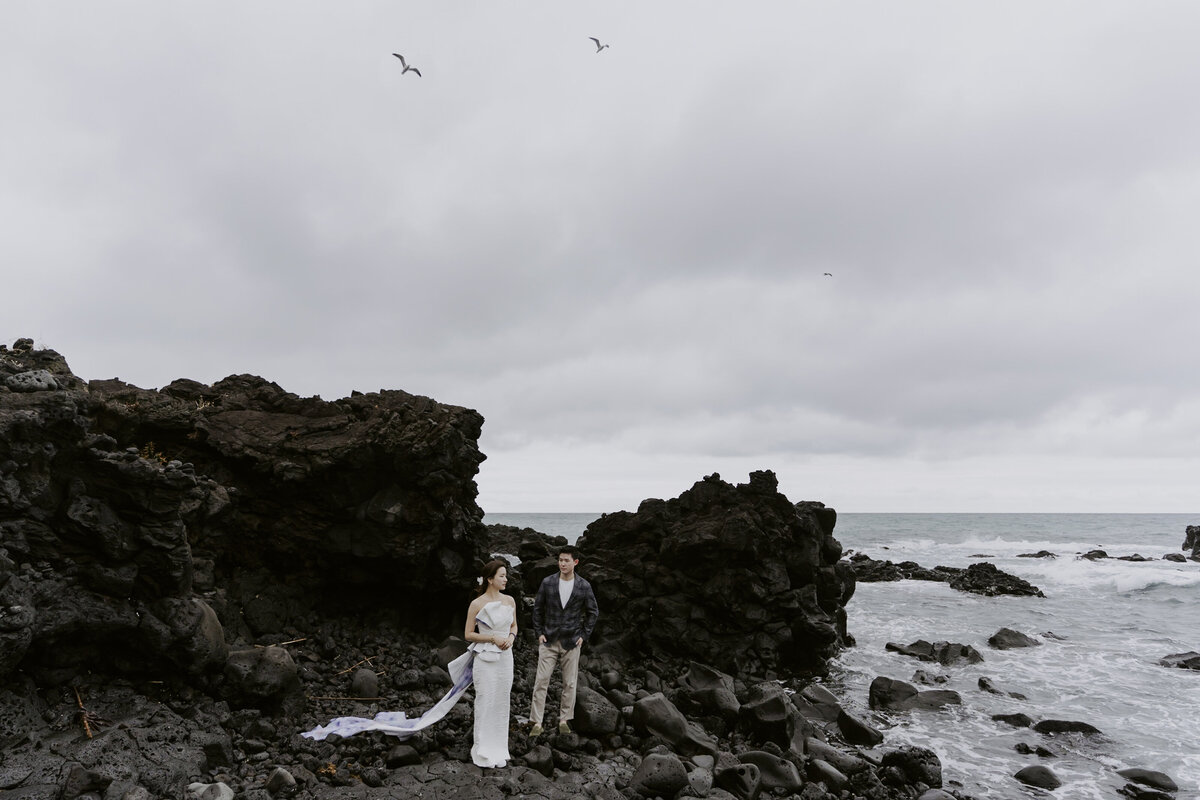 the couple standing at the cactus coastline in jeju island south korea