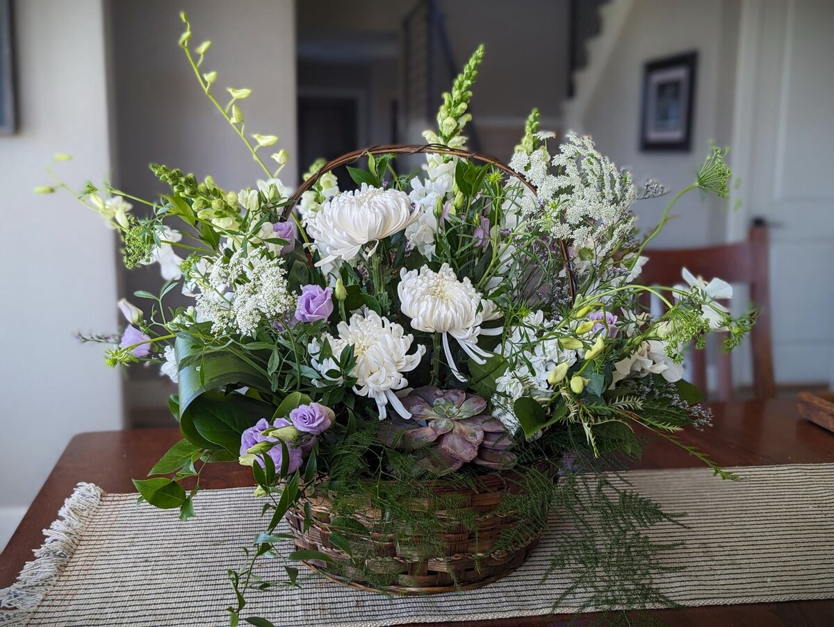 white funeral flowers with purple basket