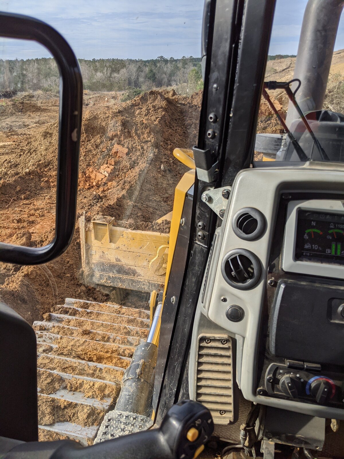 inside-excavator-looking-out-at-tire-and-dirt