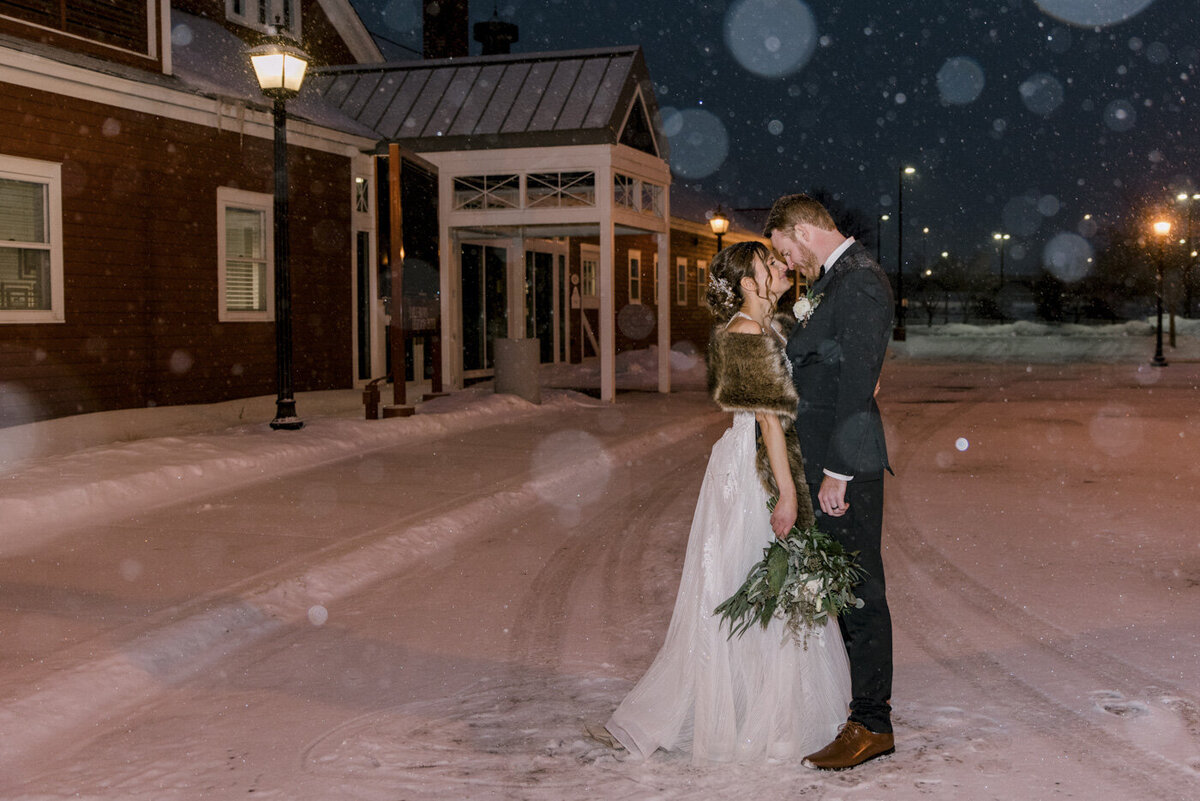 winter wedding bride and groom kiss in the snow