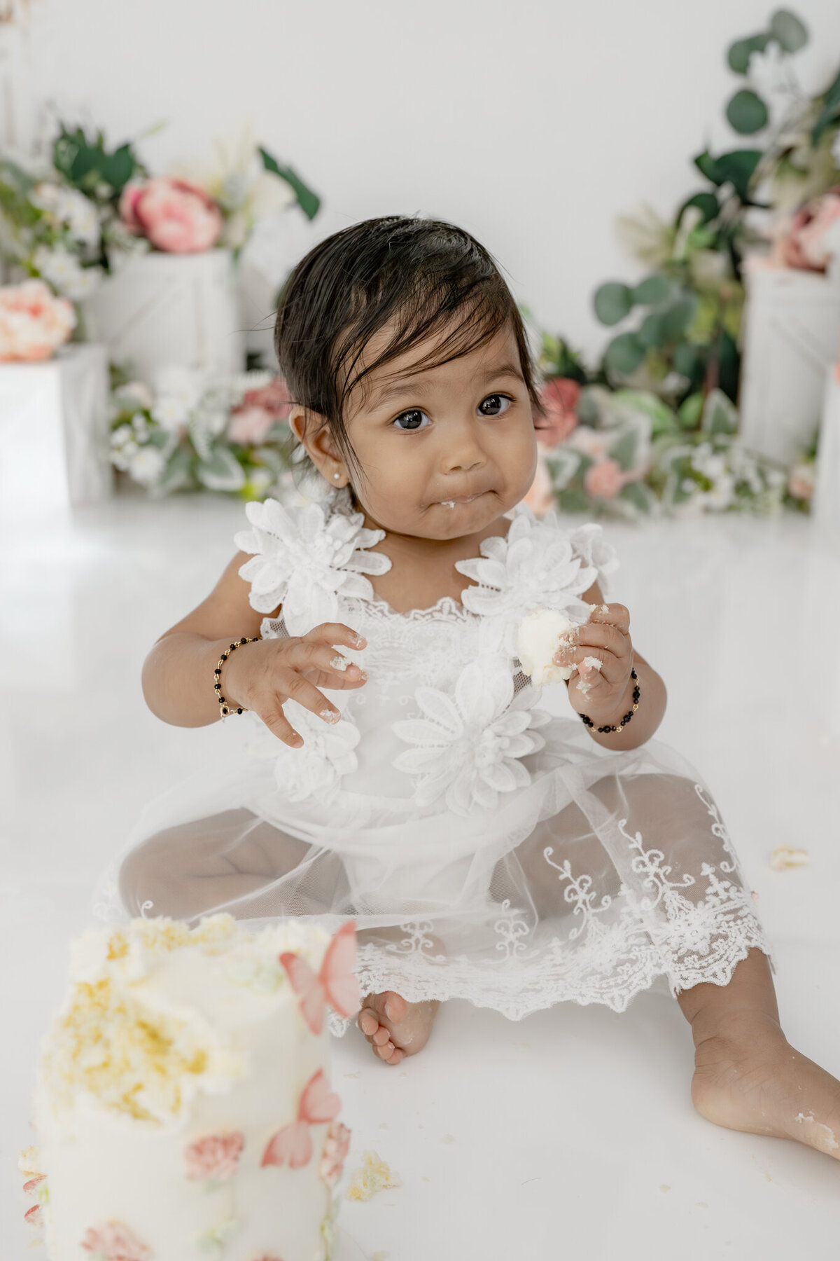Girl eating cake during floral themed cake smash session— captured by Alliston and Barrie cake smash photographer.