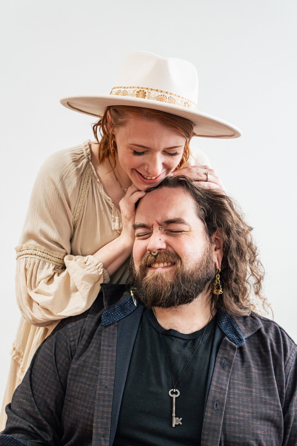 fem person in boho attire plays with their lover's hair in a styled shoot