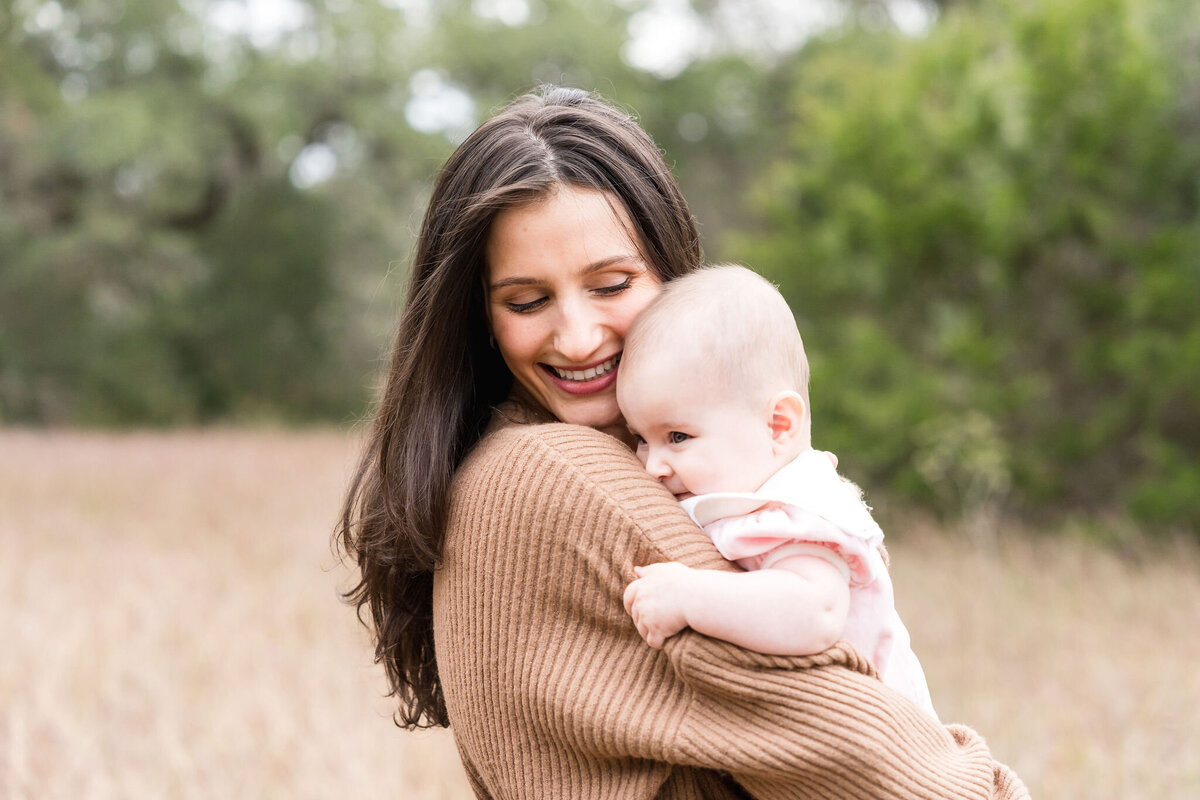 Family plays during a family photoshoot at Circle C Park in Austin, Texas.
