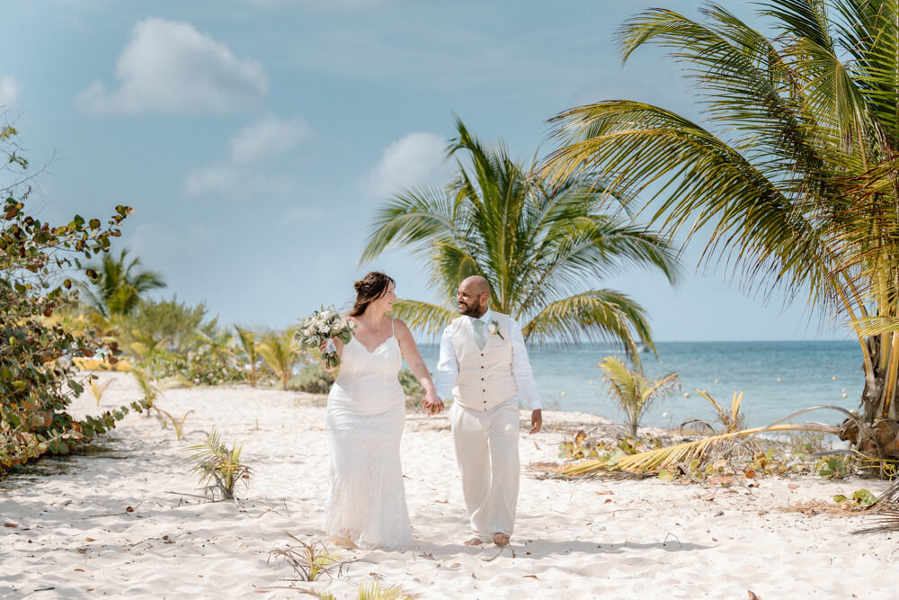 a bride and groom walk on the beach at their destination wedding in Cozumel with a cruise wedding photographer