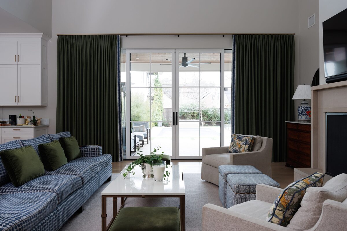 the keeping room interiors primera living room with dark green curtains and blue and white sofa