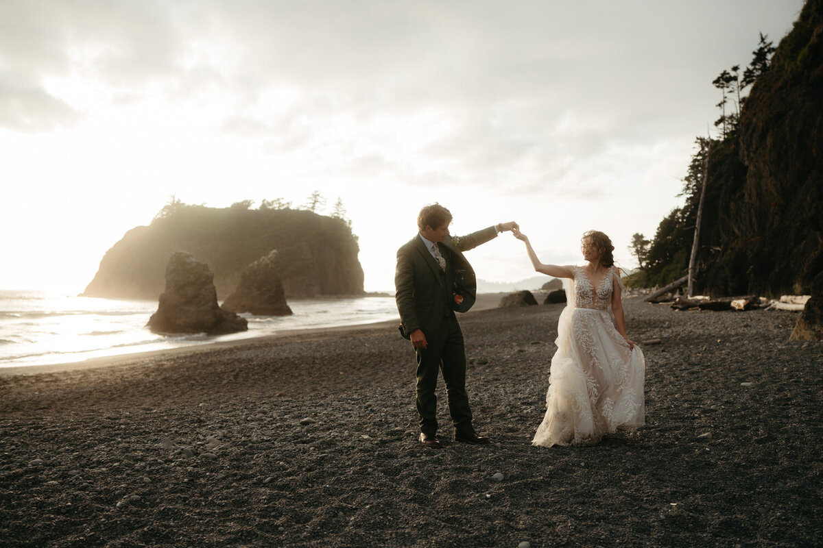 Sunset elopement on Ruby Beach in Olympic National Park, wedding couple is dancing together.