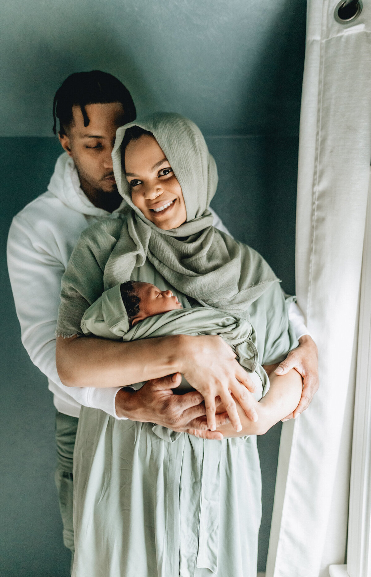 Family Photoshoot Session with dad and mom holding newborn baby.