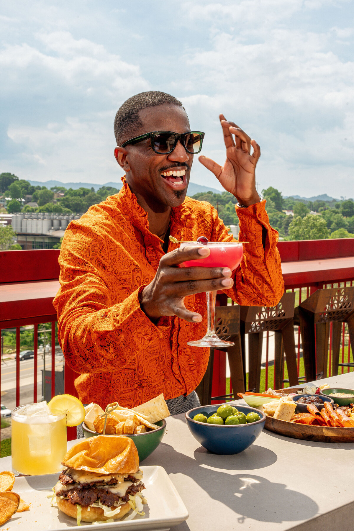 Travel and Leisure photography in Asheville, NC featuring a model cheersing a cocktail on the rooftop